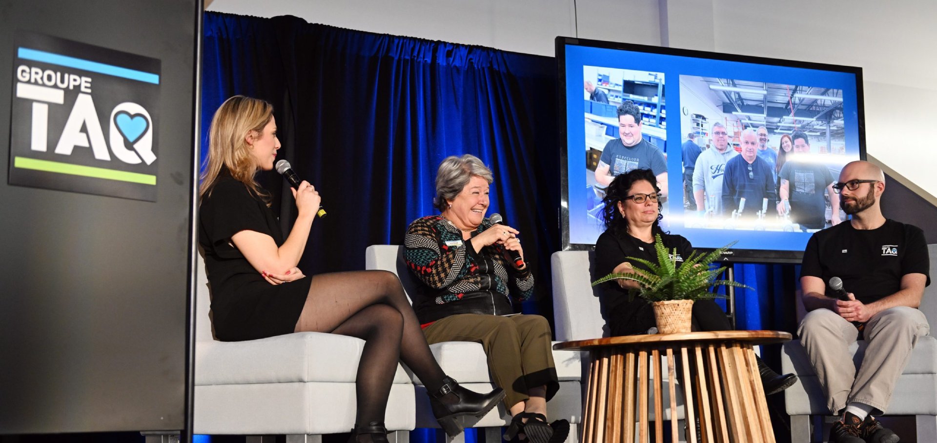 Quatre panélistes assis sur scène lors de l'événement de lancement de la campagne d'obligations communautaires de Groupe TAQ. incluant l’animatrice Pascale CV, deux employés de Groupe TAQ et une maman d'un employé discutant devant un écran affichant des photos de travailleurs.